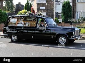 The hearse carrying the coffin in procession to the church.